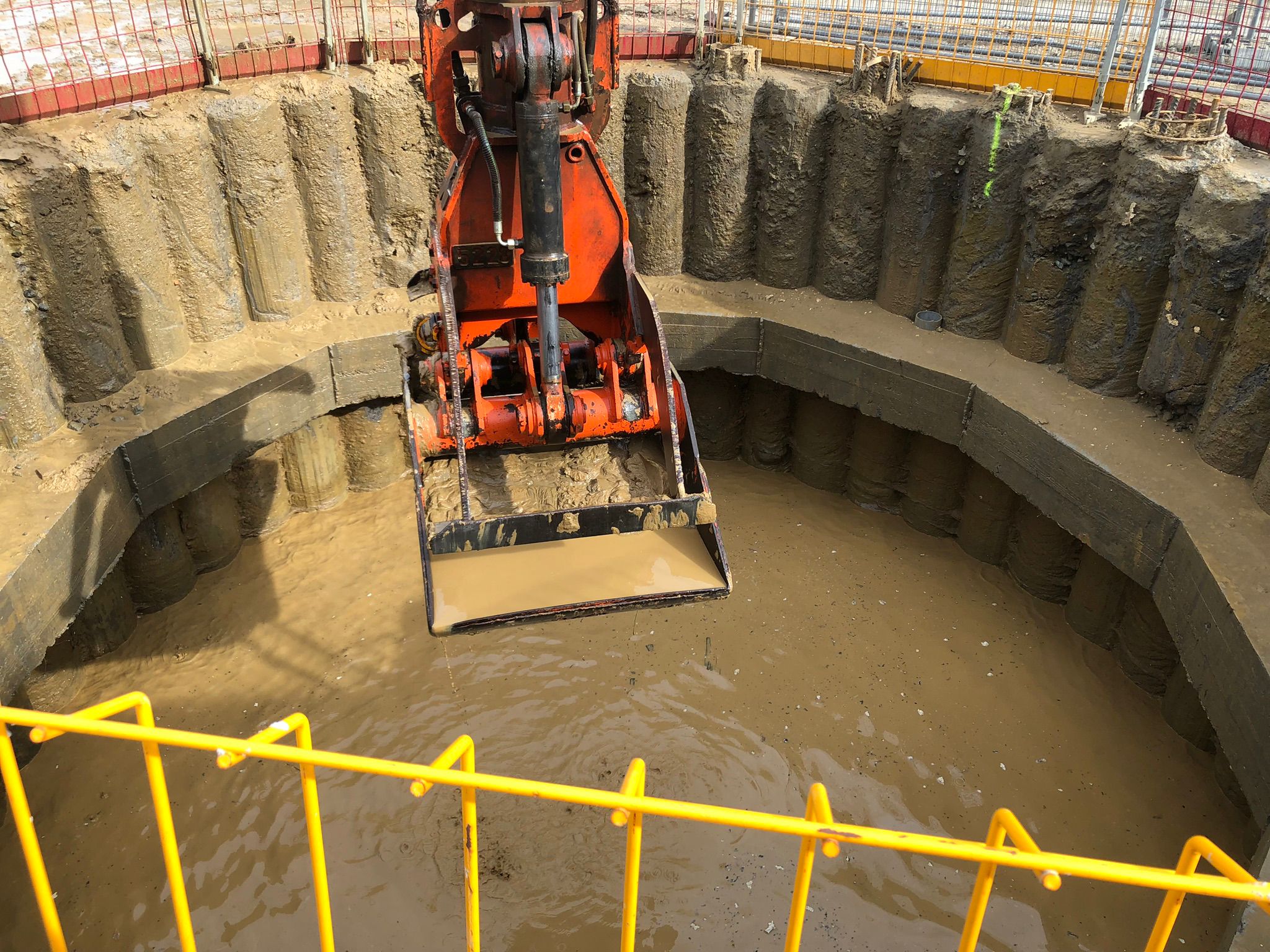 Excavating a secant pile shaft for underwater concrete